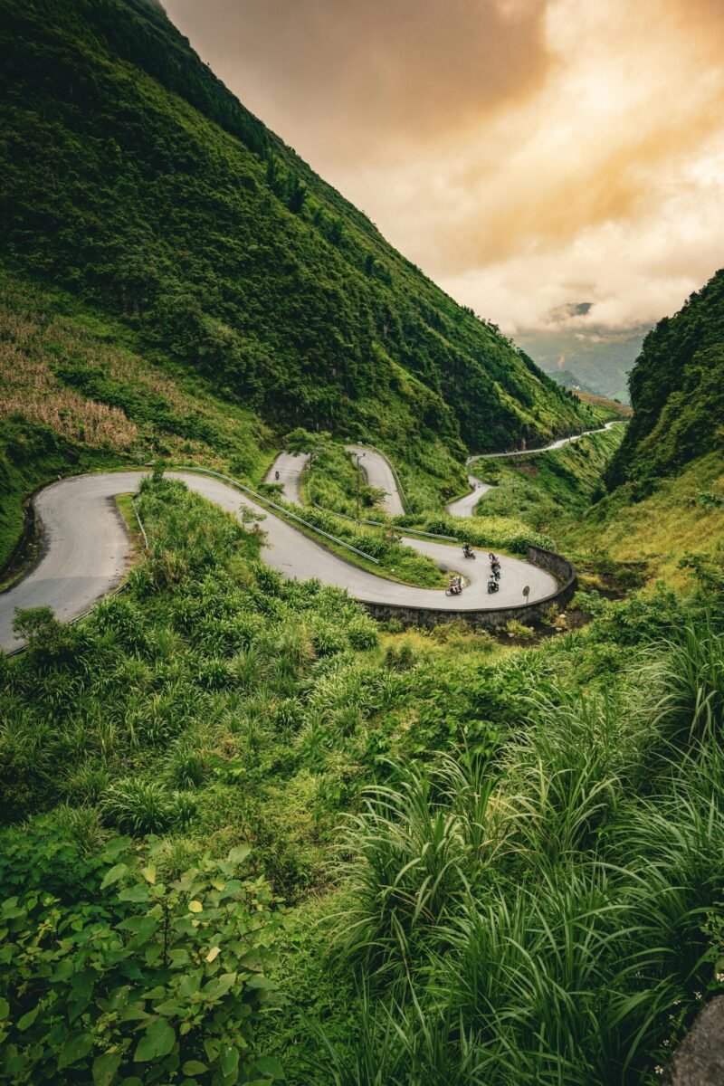 Serene winding road through lush Hà Giang mountains, perfect for adventure travel.